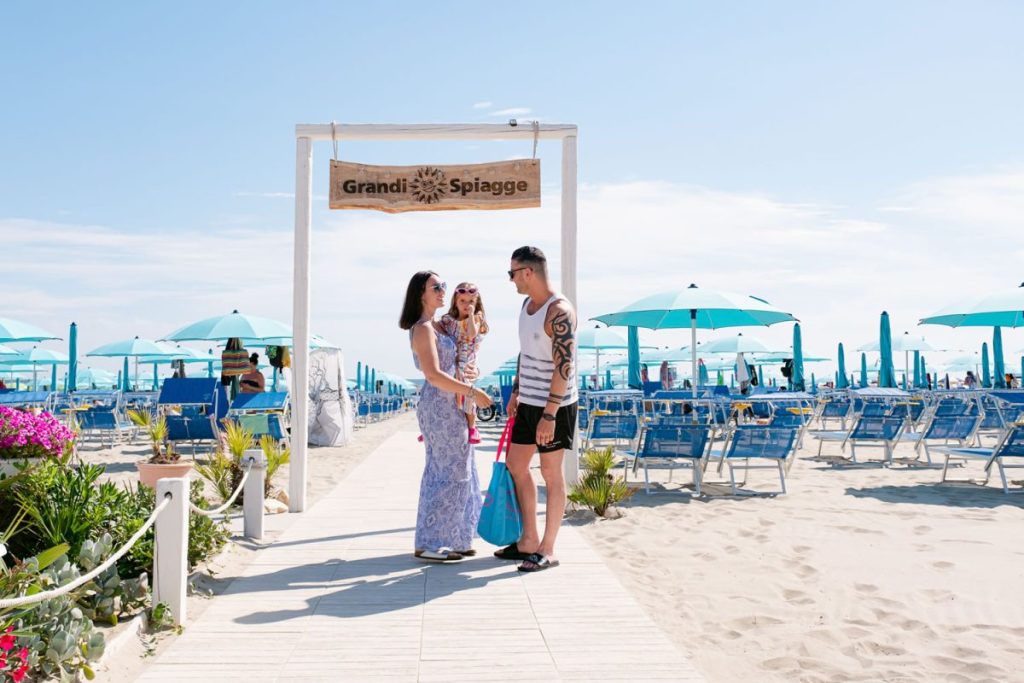 Famiglia all'ingesso del lido sulla spiaggia