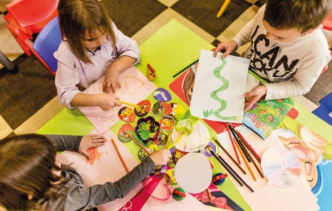 Enfants à la table à dessin avec des couleurs et des crayons